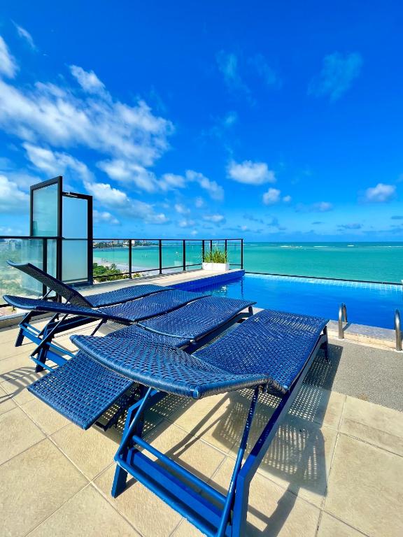 a group of blue picnic tables sitting on top of a building at Vistamar Hotel in Maceió