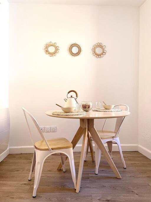 - une table avec 2 chaises et une bouilloire dans l'établissement Le Nacre 18 - Bourg-de-Péage, à Bourg-de-Péage