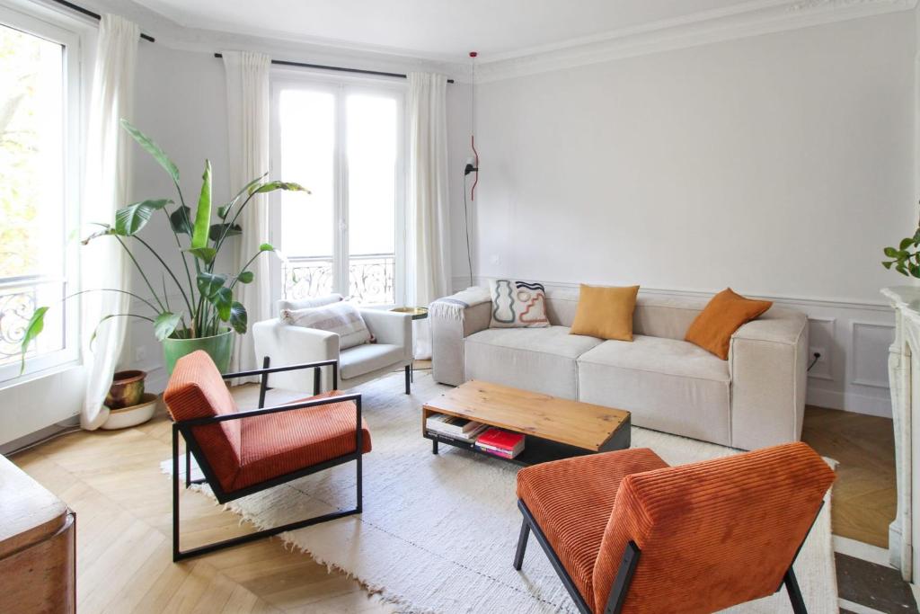 salon z białą kanapą i krzesłami w obiekcie Wonderful flat in Paris - Welkeys w Paryżu