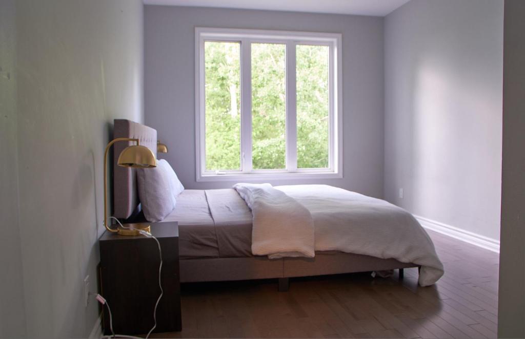 a bedroom with a bed and a window at Beautiful Nest By The Airport in Ottawa