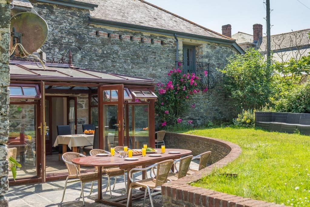 a patio with a table and chairs in a yard at Super Spacious Country house pet/party friendly. in Newquay