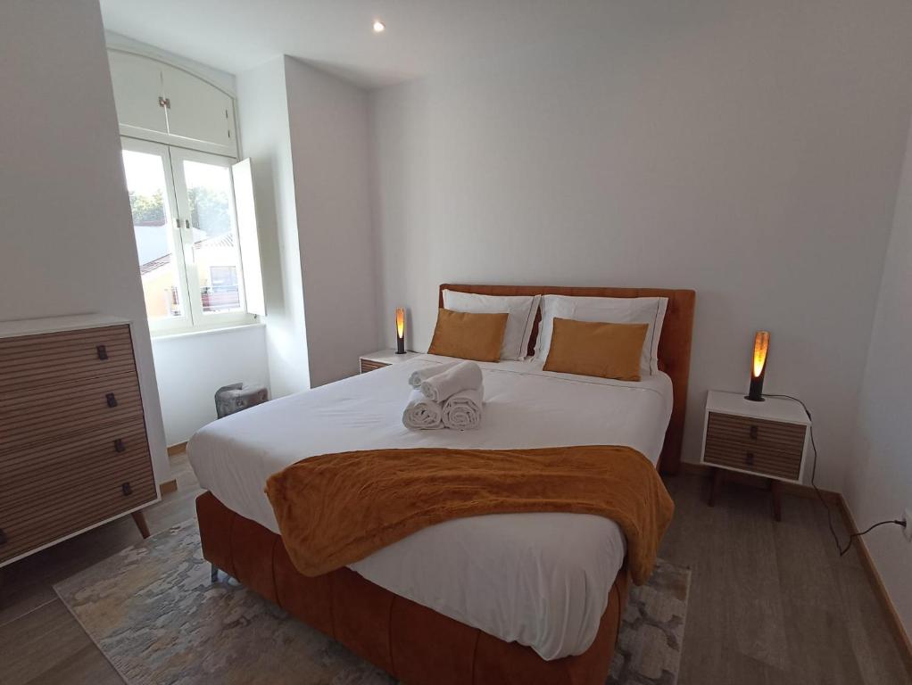 a bedroom with a large bed with two candles on it at FAMILY APARTAMENT II in Coimbra