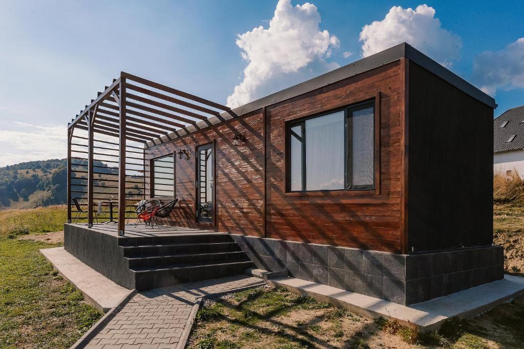 a tiny house sitting on top of a field at Zen Nest Tiny House in Şirnea