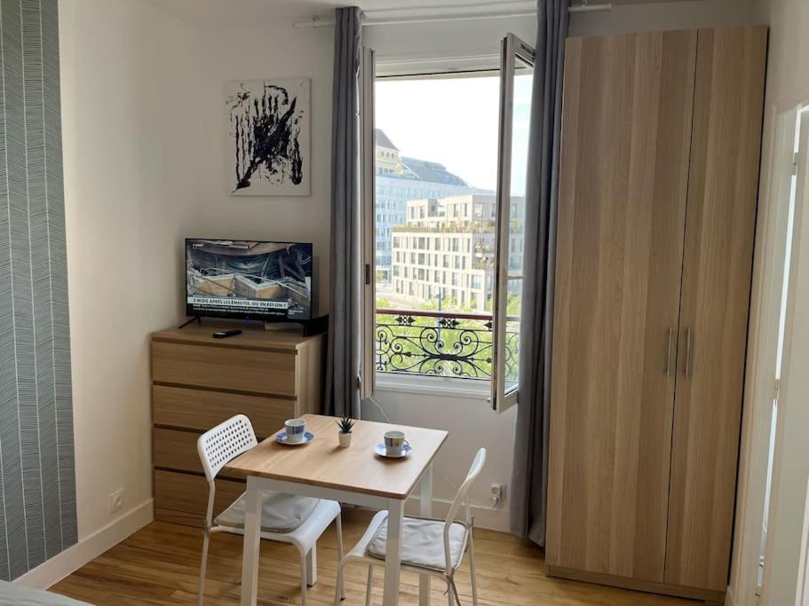a small room with a table and chairs and a window at Studio number 7 in Pantin