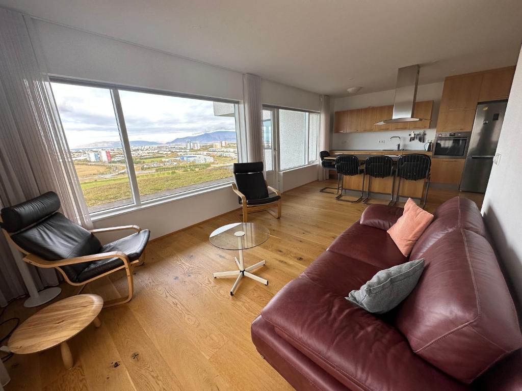 salon z brązową skórzaną kanapą i krzesłami w obiekcie Apartment in Austurkór- Birta Rentals w Reykjavík