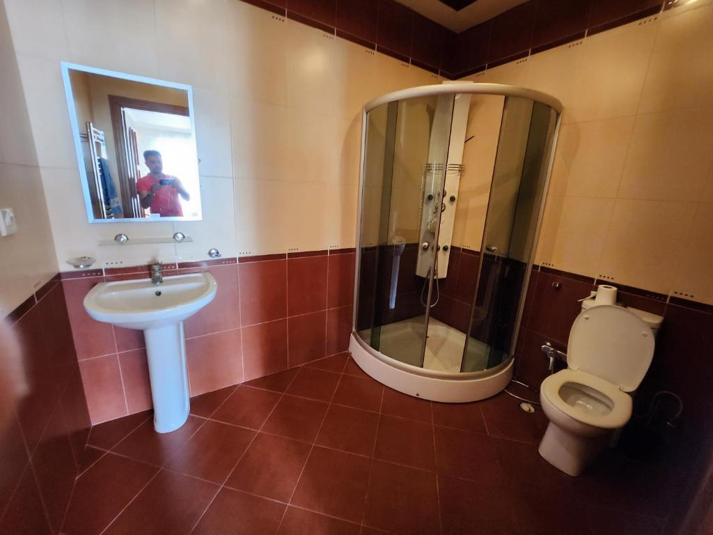 uma casa de banho com um chuveiro, um WC e um lavatório. em Hatai em Baku