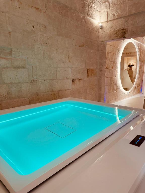 ein Schwimmbecken in einem Raum mit einer Steinwand in der Unterkunft Secret Suite in Monopoli