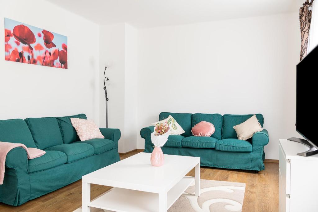 a living room with a green couch and a table at BoRóza Vendégház in Zebegény