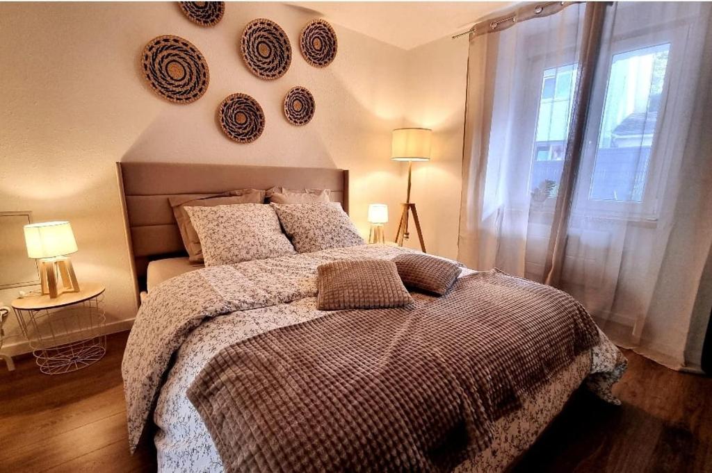 ein Schlafzimmer mit einem Bett mit Platten an der Wand in der Unterkunft Le 31 - Mulhouse Pfastatt in Pfastatt