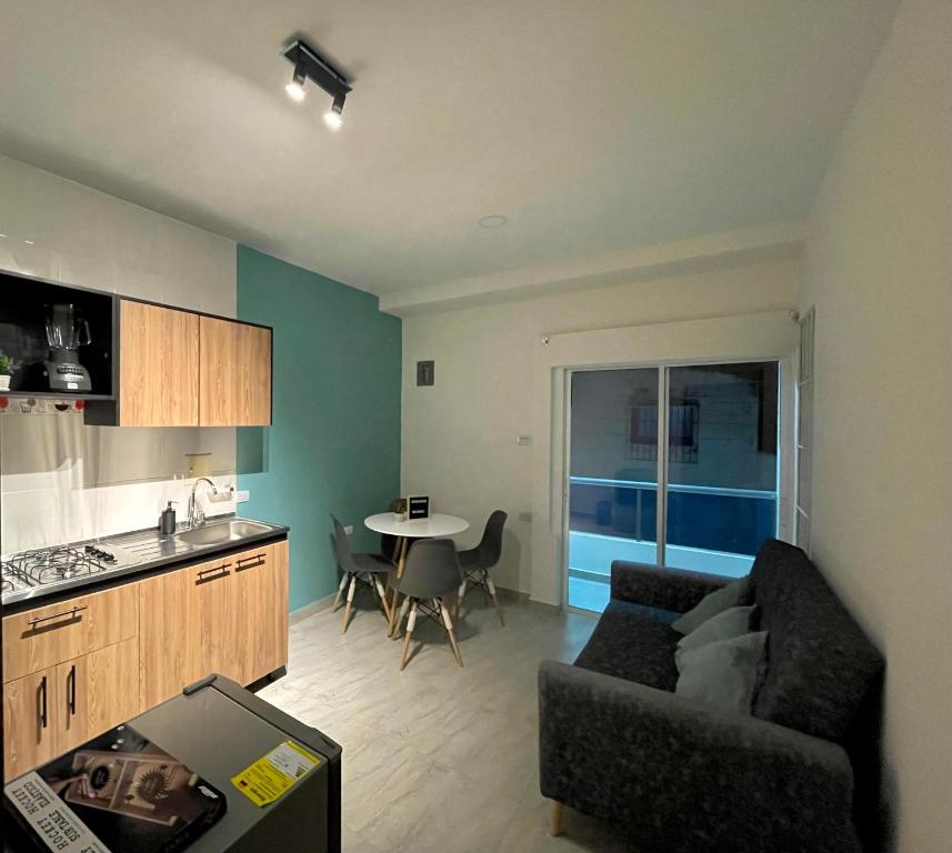 a kitchen and a living room with a couch and a table at Bonito Apartamento Monteria in Montería
