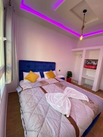 a bedroom with a bed with purple lights on it at Padova Surf House in Imsouane