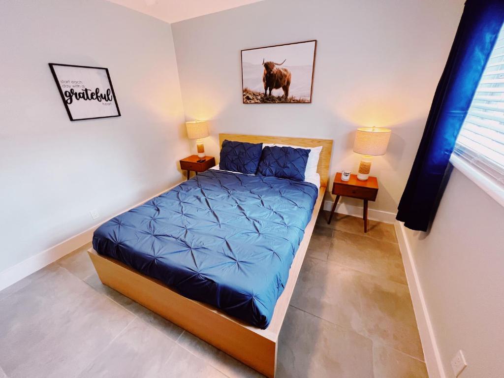 1 dormitorio con 1 cama con sábanas azules y 2 lámparas en Holiday Park Apartments by Lowkl, en Fort Lauderdale