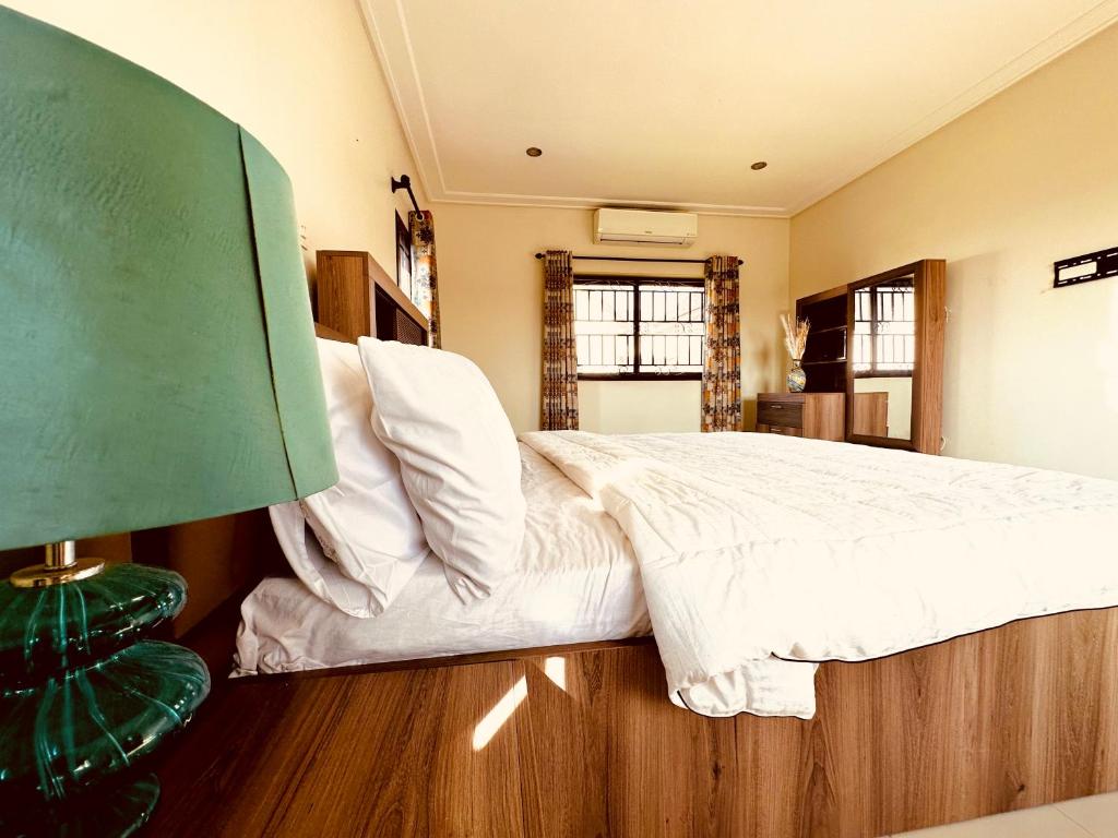 ein Schlafzimmer mit einem großen Bett mit weißer Bettwäsche in der Unterkunft Aspen Luxury Villa in Accra