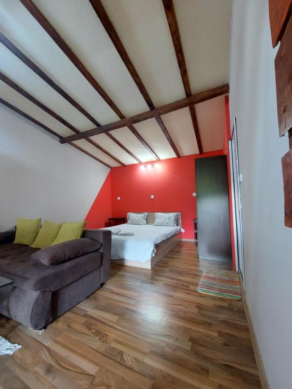 uma sala de estar com uma cama e um sofá em Стаи за гости Върбите em Sapareva Banya