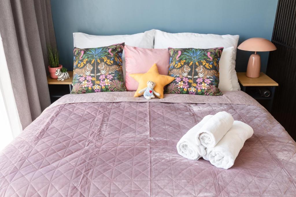 a pink bed with towels and pillows on it at Urban Chic Residences in Prague