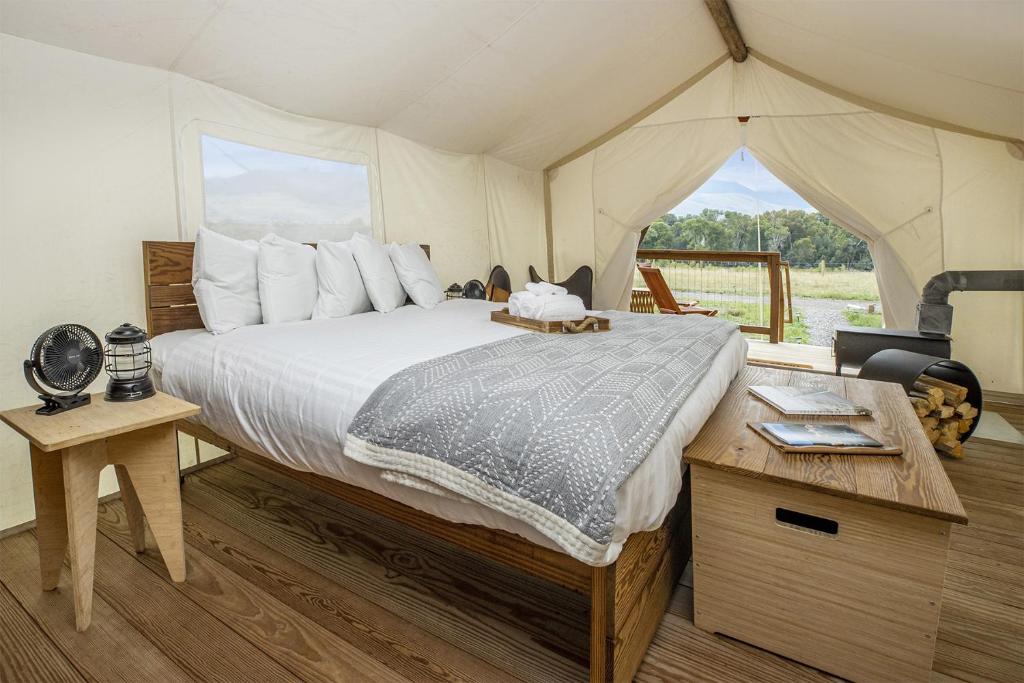 1 dormitorio con 1 cama en una tienda de campaña en Under Canvas North Yellowstone - Paradise Valley, en Livingston