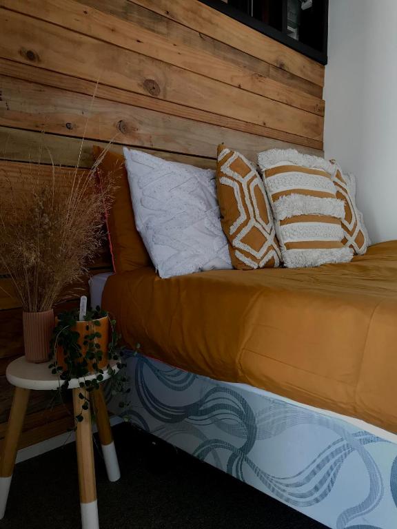 a bed with pillows on it in a room at Onehunga Garden Tinyhouse in Auckland