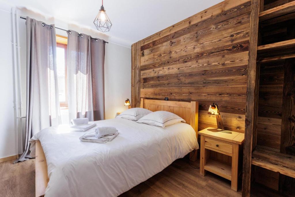 a bedroom with a large bed and a wooden wall at la casse deserte in Arvieux
