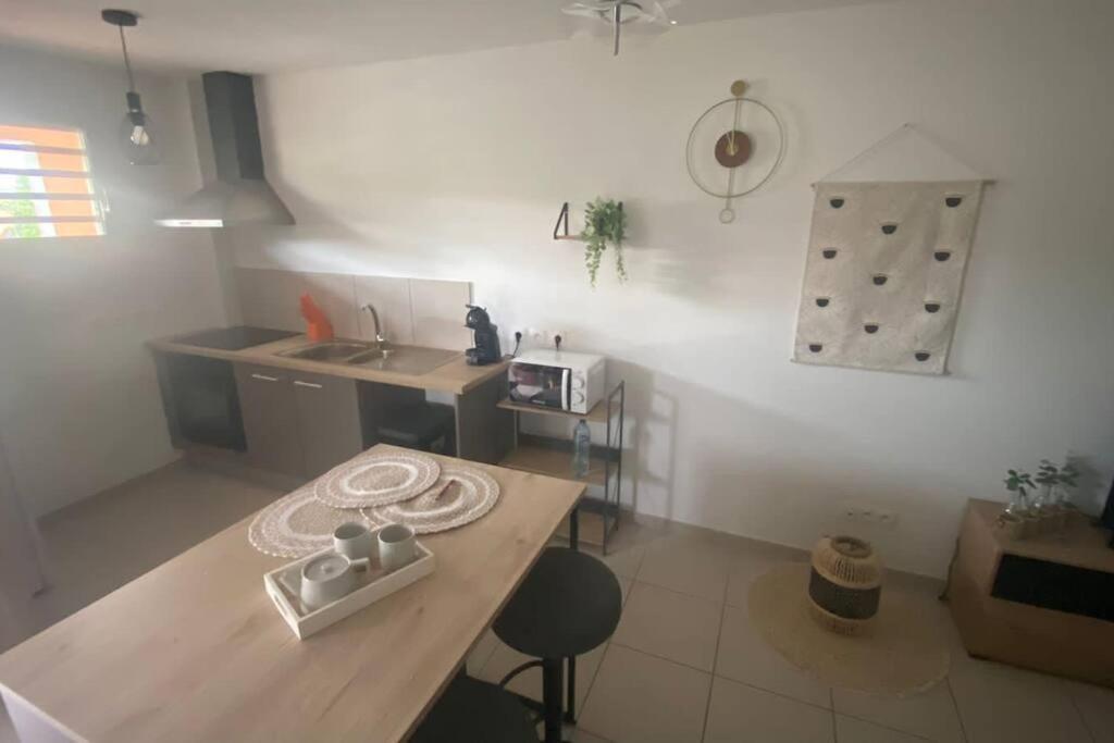 a kitchen with a wooden table and a counter top at Appartement T2 très cosy in Cayenne
