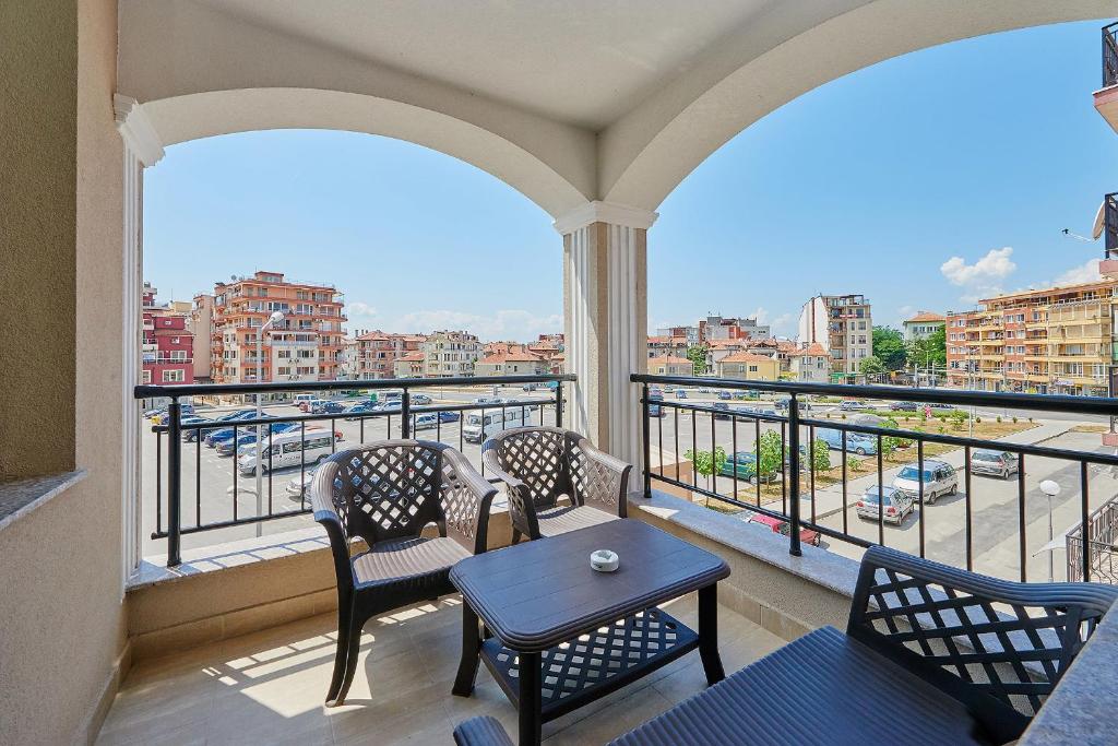 a balcony with chairs and a table and a view of a city at Evi Apartments 2 in Pomorie