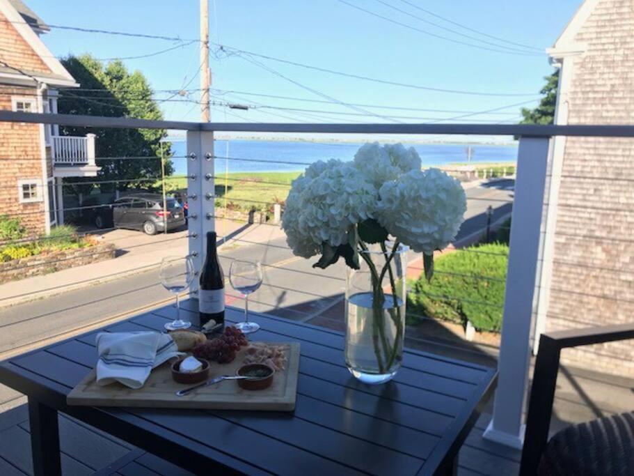 un jarrón de flores sobre una mesa en un balcón en Circa 1725 home w/Roof Deck and Water Views en Newburyport