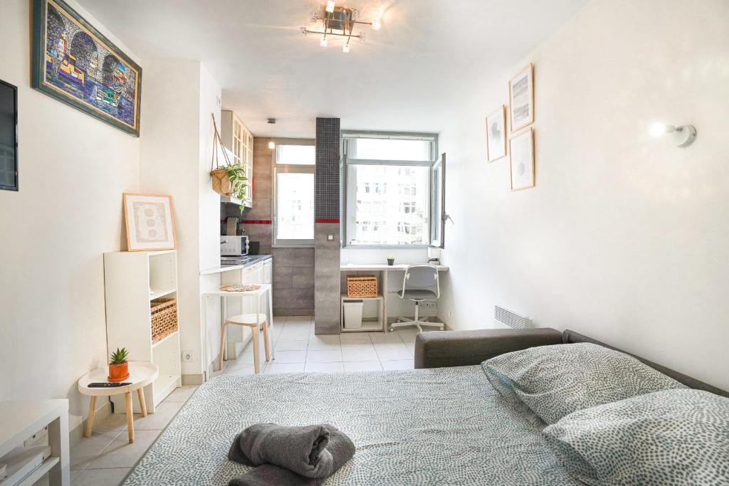une petite chambre avec un lit et une cuisine dans l'établissement Studio cosy hypercentre proche Vieux-Port et métro, à Marseille