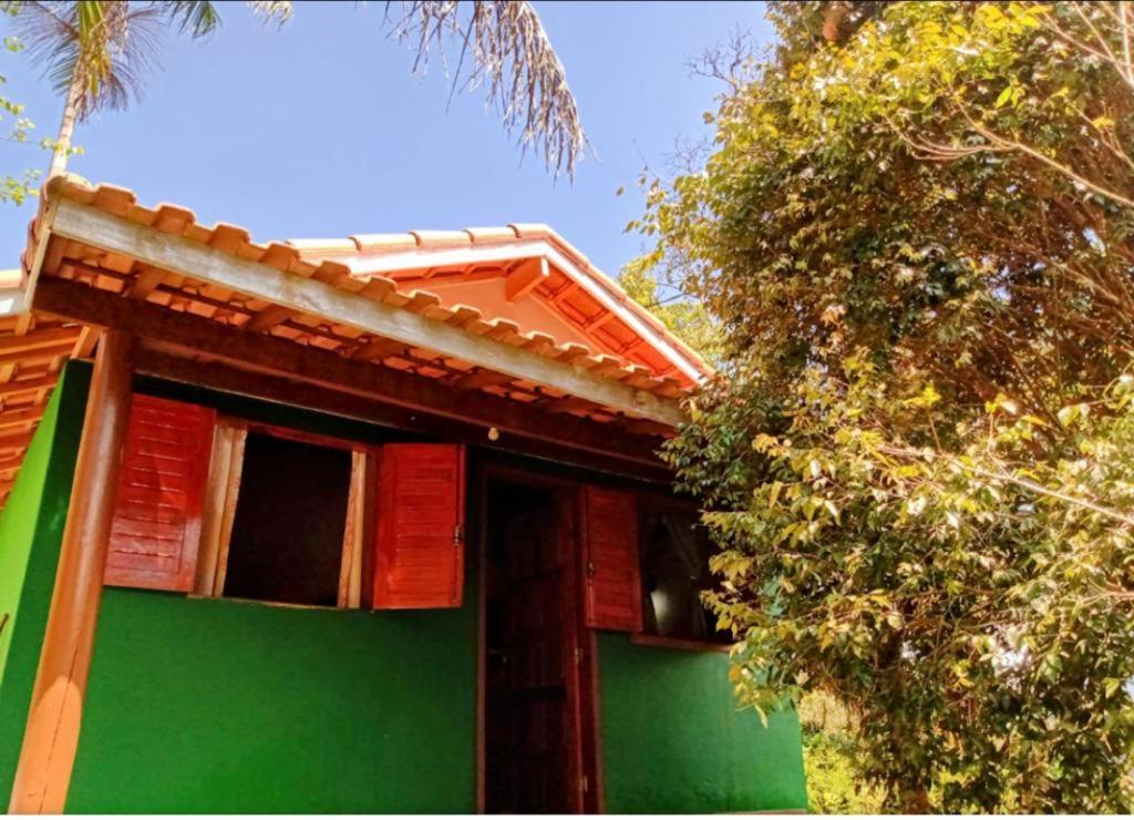 una casa verde y roja con un árbol en Chalé da Flor, en Visconde De Maua