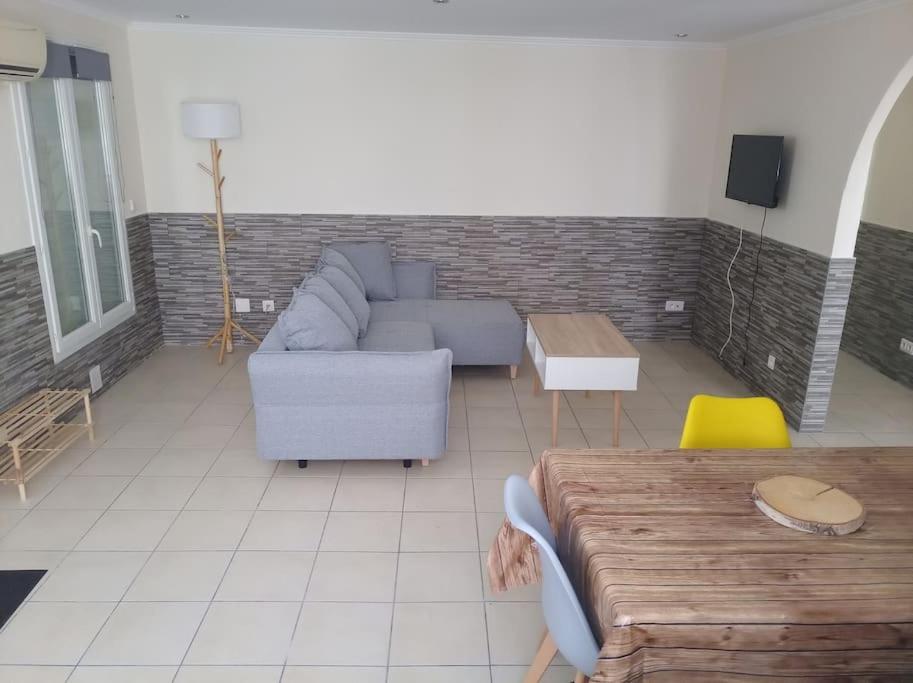 een woonkamer met een bank en een tafel bij Appartement en RDC in Argelès-sur-Mer