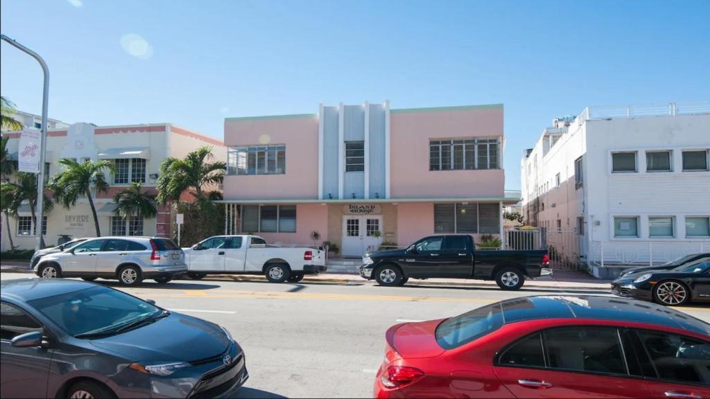 a parking lot with cars parked in front of a building at Island House South Beach in Miami Beach