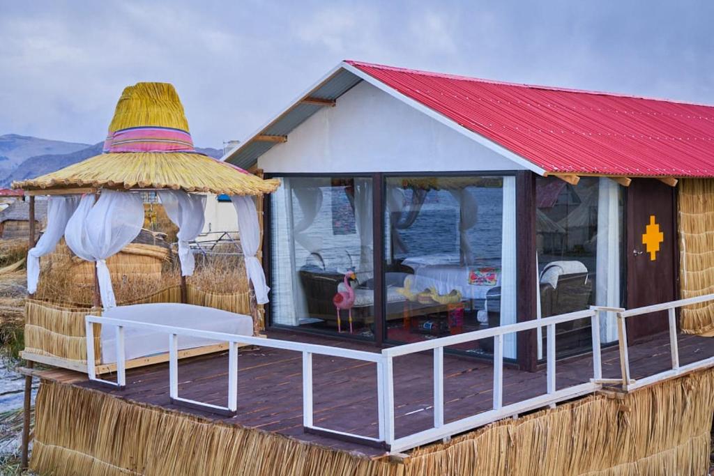 ein kleines Haus mit rotem Dach und einer Terrasse in der Unterkunft Mojsa titicaca lodge in Puno