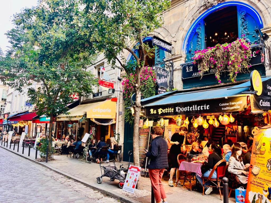 Eine Gruppe von Menschen, die in einer Stadt auf einer Straße spazieren in der Unterkunft Paris rare pearl 5e Notre Dame Saint Michel in Paris