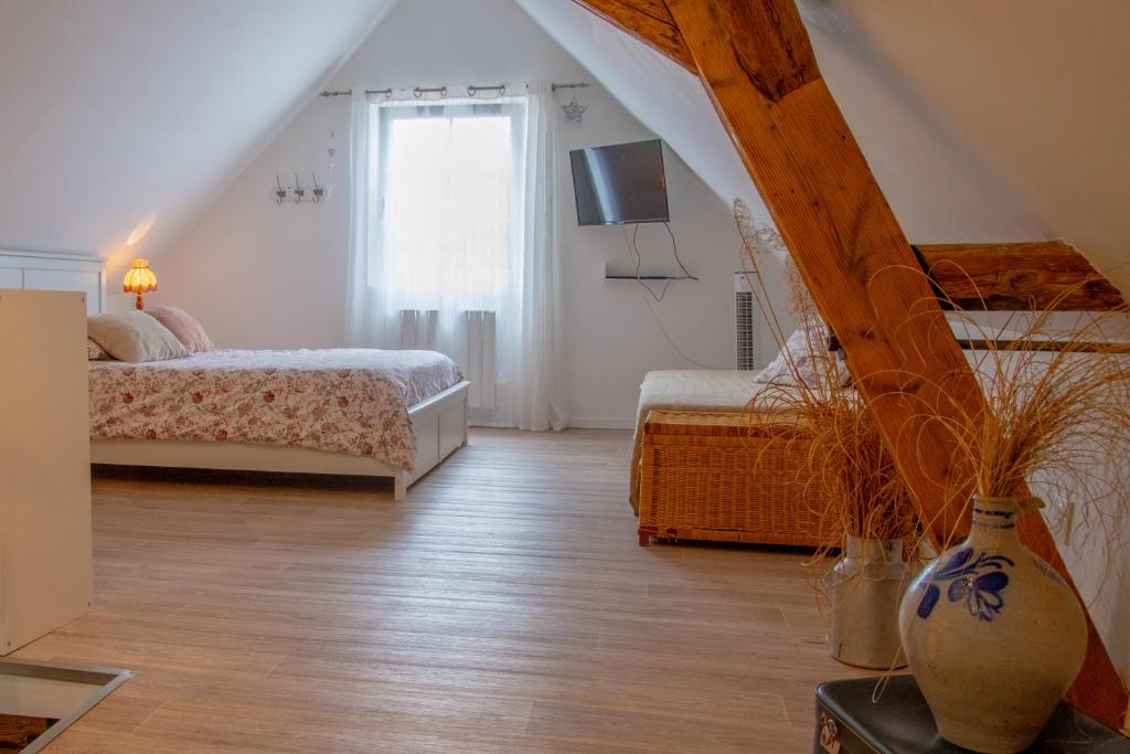 een slaapkamer op zolder met 2 bedden en een raam bij Gîte indépendant - Bretzel et Bergamote in Richtolsheim