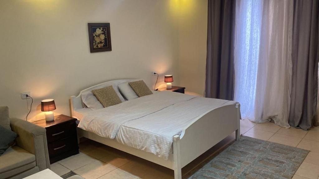 sypialnia z łóżkiem, krzesłem i 2 lampami w obiekcie 1 bedroom first w mieście Amman