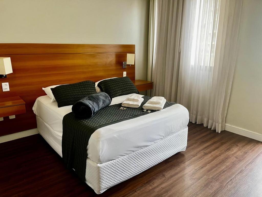 a bedroom with a bed with two towels on it at Belíssimo FLAT - Faria Lima - Pinheiros in Sao Paulo