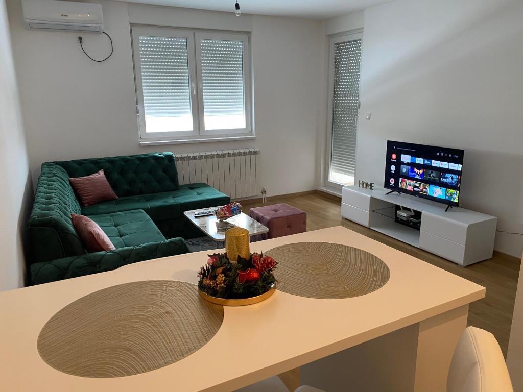 a living room with a table and a couch at Dream Apartment in Lukavica
