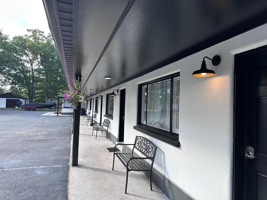 szereg ławek siedzących obok budynku w obiekcie Star Gate Motel w mieście Indian River