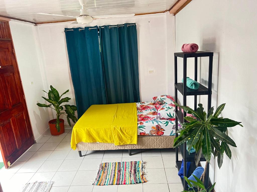 1 dormitorio con 1 cama con manta amarilla en Mochis en Quepos