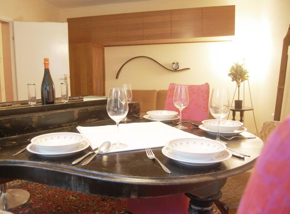 a table with empty plates and wine glasses on it at Nobel-Prize-Appartement in Graz