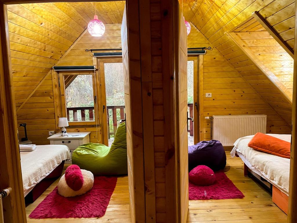 um quarto com duas camas com almofadas coloridas no chão em Cozy Cabin in the Woods em Brezovicë