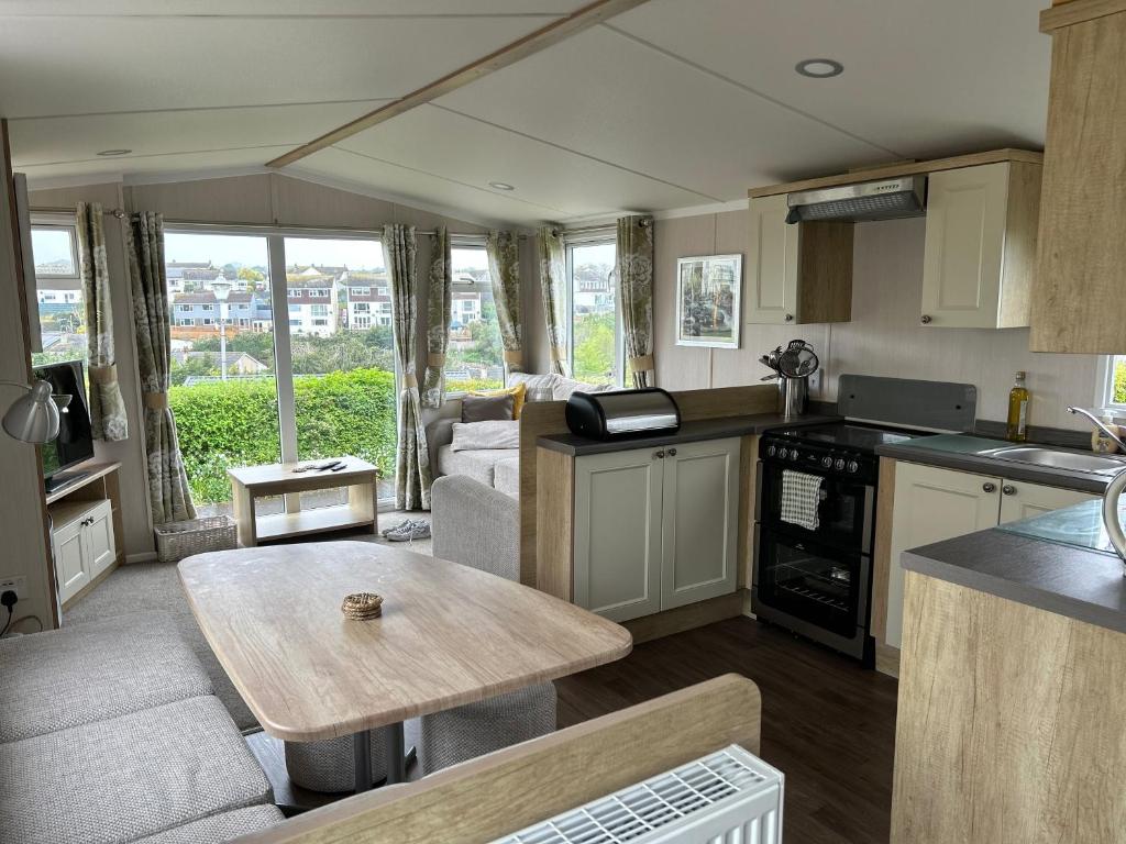 a kitchen and living room with a table in a caravan at High View in Torquay