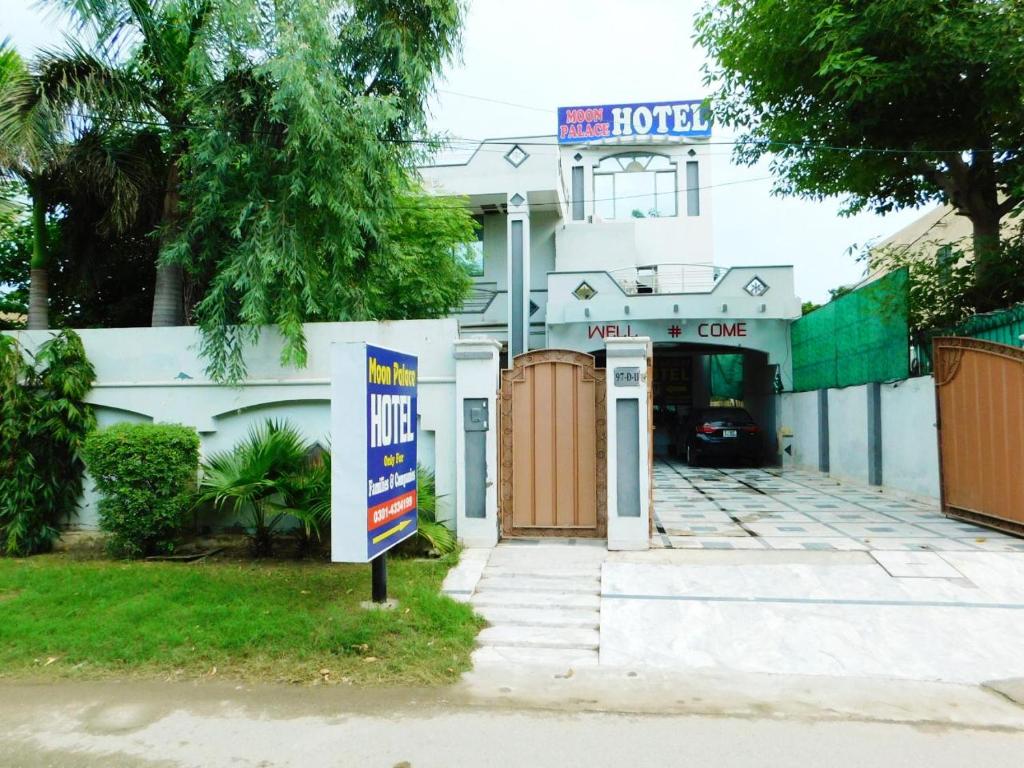 un hotel con un cartel frente a un edificio en Moon Palace Hotel Lahore, en Lahore