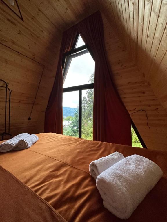 un letto in una camera con una grande finestra di Collodi Cottages a Tba