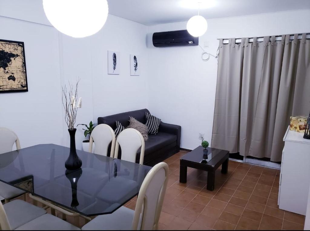 ein Wohnzimmer mit einem Glastisch und einem Sofa in der Unterkunft Departamento en capital Mendoza con estacionamiento incluido in Mendoza