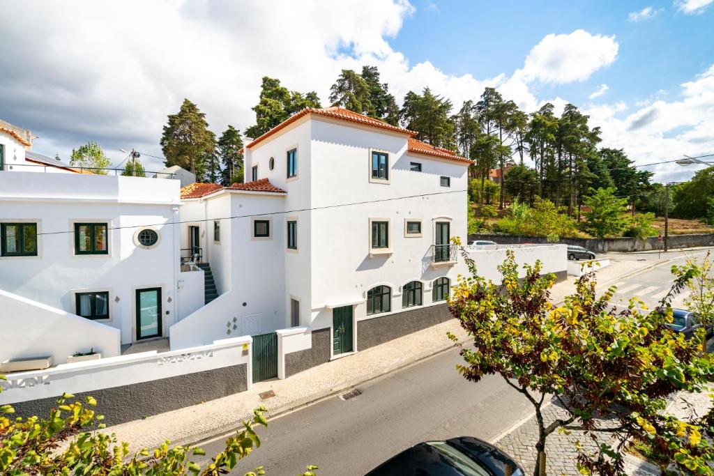 a white building on the side of a road at FOREST VILLAS - GUEST HOUSE in Leiria