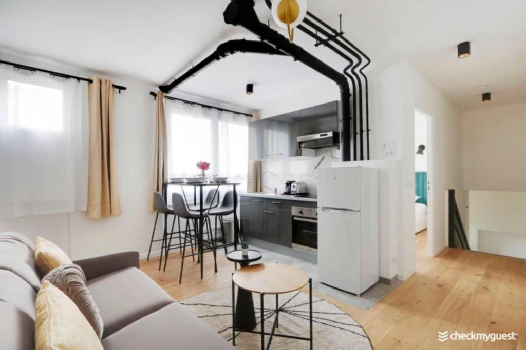 a living room with a couch and a kitchen at Lovely cozy appartement in Paris 15ème in Paris