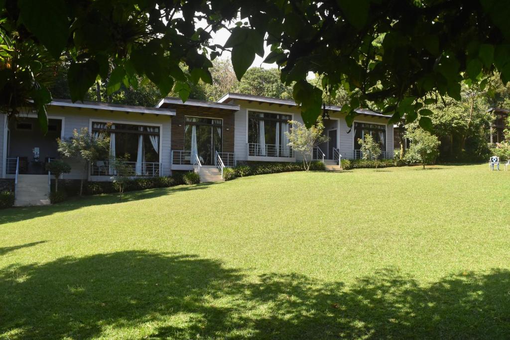 a house with a large lawn in front of it at YerbaBuena Lodge in Monteverde Costa Rica