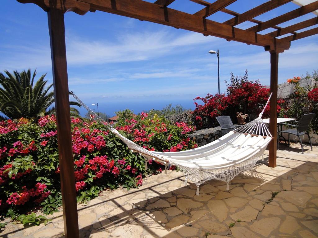 a hammock on a patio with flowers at Casas Erel in Puntagorda
