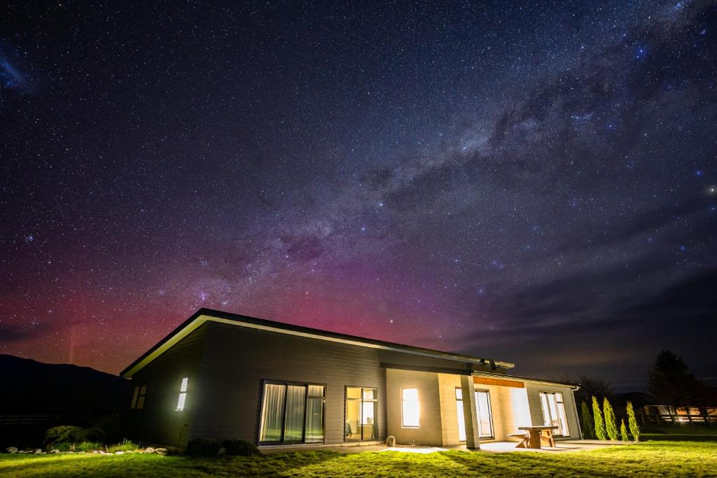 een klein huis onder een sterrenhemel 's nachts bij Ben Ohau Views On The Drive in Twizel