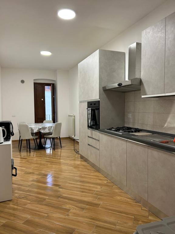 a kitchen with a table and a dining room at La Dimora del Coach in LʼAquila