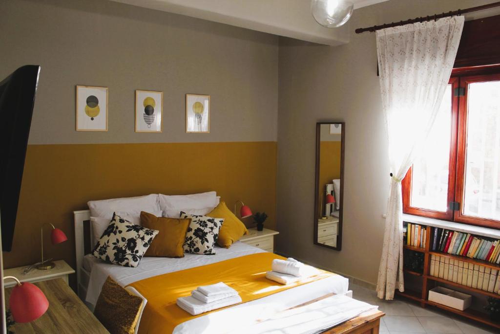 een slaapkamer met een bed met gele lakens en een spiegel bij Vomero Parthenope Home in Napels